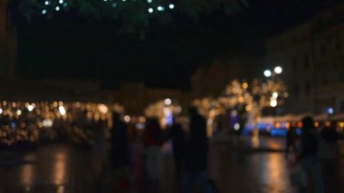 Polonya 'nın Krakow kentindeki kasaba meydanında akşam üstü bulanık Noel pazarı. Tatiller, satış ve perakende konsepti 
