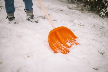Adam kar fırtınasından sonra kaldırımdan karı kaldırıyor. Kış zamanı. Avrupa. Yüksek kalite fotoğraf