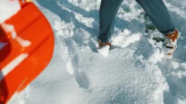 Adam kar fırtınasından sonra kaldırımdan karı kaldırıyor. Kış zamanı. Avrupa. Yüksek kalite fotoğraf