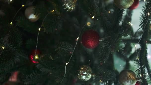 クリスマスツリーのクリスマスボールを閉じます バックグラウンドのボヘ ガーランド 新年コンセプト — ストック動画