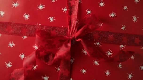明るいクリスマスツリーの背景に弓でクリスマスギフトと居心地の良いセーターで陽気でかわいい若い女性の手 リボン付きのスタイリッシュな女性のプレゼント — ストック動画