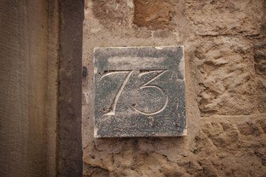 73 numarayla birlikte eski, paslı, paslı sokak adresi plakası. Yüksek kalite fotoğraf