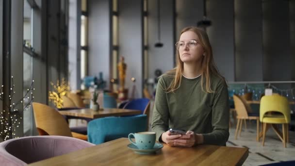 Frau Schaut Traurig Auf Smartphone Einem Café Das Porträt Der — Stockvideo