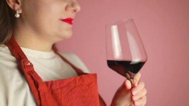 Şatafatlı muhteşem kadın şarap tatma etkinliğinde kırmızı şarap içiyor, içiyor ve popüler bir karışımın kalitesini test etmekten zevk alıyor. Yüksek kaliteli FullHD görüntüler