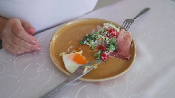 年轻女人用刀叉吃着美味的早餐 新鲜沙拉和薄饼放在瓷盘上 优质Fullhd影片 — 图库视频影像