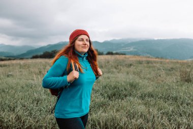 Akıllı telefonlu genç bir kadın dağlarda sinyal yakalıyor. Yolculuk, ulaşım, seyahat, teknoloji ve insan kavramı. Yüksek kalite fotoğraf