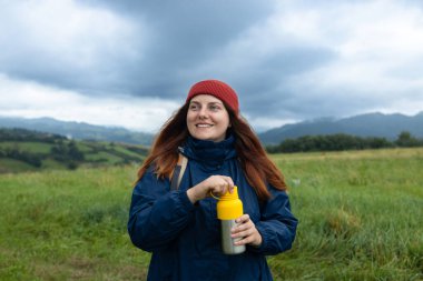 Kadın gezgin, dağ manzaralı bir kahve içer. Seyahat konsepti. Saf doğal su. Yüksek kalite fotoğraf