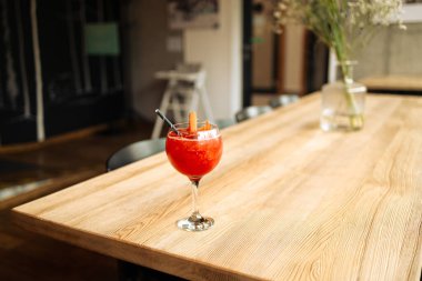 Tarz kafenin ahşap masasında şeffaf bir bardakta greyfurt, buz ve biberiyeli portakal kokteyli. Yüksek kalite fotoğraf