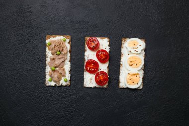 Kaynamış yumurtalı sandviç, vişneli domates, konserve ton balığı, sarımsak ve baharat karışımı. Yüksek kalite fotoğraf