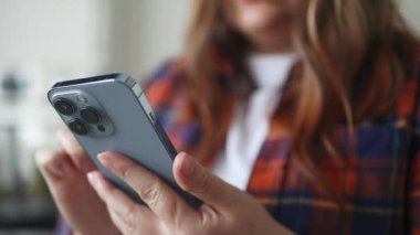 Genç beyaz kadın ellerinin cep telefonu kullanması, evde dinlenmesi yakın plan. Yüksek kaliteli FullHD görüntüler