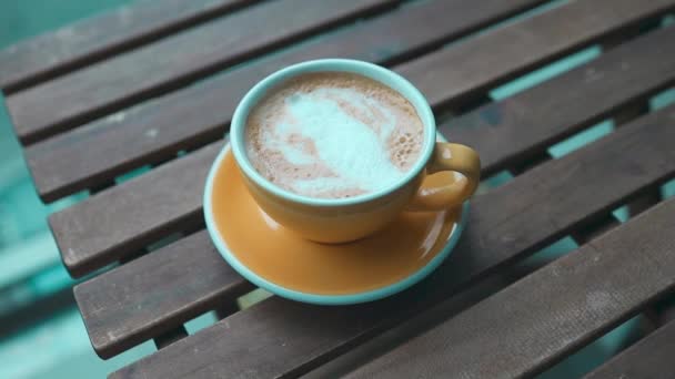 将黄色的拿铁咖啡杯或卡布奇诺咖啡杯放在数字平板上靠窗的阳台上 早上的咖啡加白杯中的蒸汽 优质Fullhd影片 — 图库视频影像