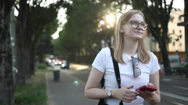 Hüzünlü Sarışın Kadın Elinde Cep Telefonuyla Şehir Ulaşımıyla Ilgili Bilgileri — Stok video