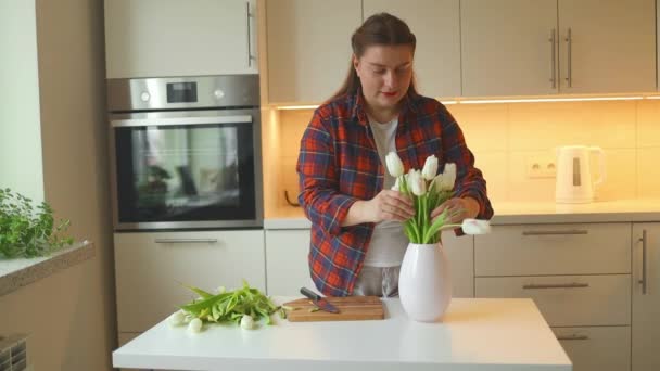 Λευκή Γυναίκα Βάζει Φρέσκιες Τουλίπες Στο Βάζο Στην Κουζίνα Ανθισμένη — Αρχείο Βίντεο