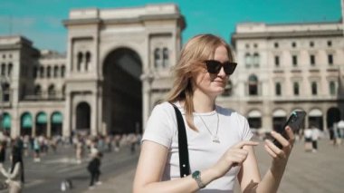 Selfie kızı. Genç bayan turist Milan 'daki ünlü Duomo katedralinin yakınında akıllı telefonuyla selfie çekiyor. Milan 'da iyi tatiller. Yüksek kaliteli FullHD görüntüler