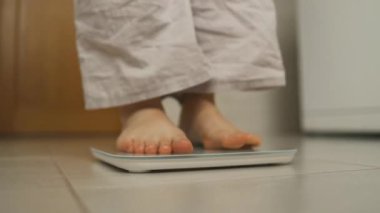 Kadın ayağı banyo terazisi. Kilo verme konsepti. Banyo terazisinde duran kız bacakları. Yüksek kaliteli FullHD görüntüler