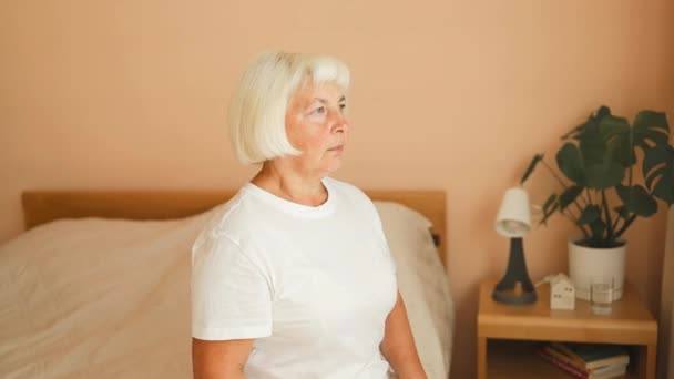 在床上坐着的中年妇女 早上用手捂着脸 患有气压计性头痛偏头痛 老年妇女不高兴 不健康或个人问题的概念 — 图库视频影像