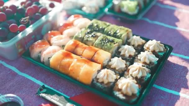 黒石板にサーモンとマグロの魚をセットした寿司ロール 黒い石のスレートにチョップスティックでアジア料理 伝統的な日本料理のリアルな眺め 高品質のフルHd映像 — ストック動画