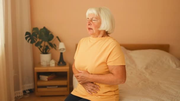 胃の痛み 胃炎に苦しんでいる腹の胃に触れる病気の不幸な白人70代の女性の肖像画 高品質のフルHd映像 — ストック動画