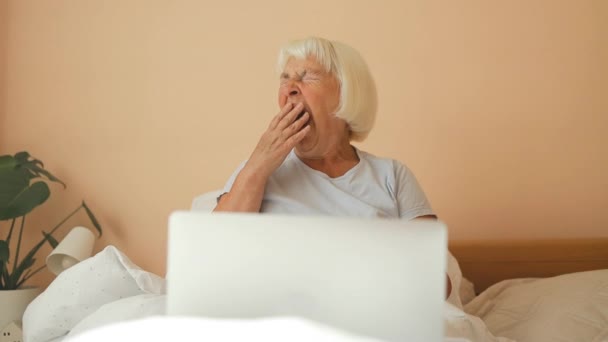Luie Vermoeide Jaren Senior Vrouw Geeuwt Liggend Bed Met Laptop — Stockvideo