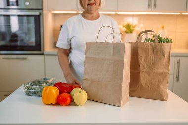 Mutlu ev hanımı kadın, ev mutfağında karton kutu açıyor, marketten gıda ürünleri üretiyor, süpermarket teslimat lojistik servisinden alışveriş yapıyor. Yüksek kalite fotoğraf