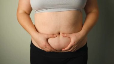 Şişman kadınların göbeğinde yağ kıvrımları var. Aşırı kilo, obez kadın, diyet ve aşırı kilo sorunları kavramı. Yüksek kaliteli FullHD görüntüler