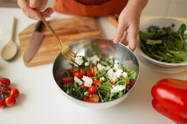 Bayan taze sebze salatası pişiriyor, sprey peyniri ekliyor ve bowling 'e baharat katıyor, evde sağlıklı vejetaryen yemekleri yiyor, yakından çekiyor. Yüksek kaliteli FullHD görüntüler