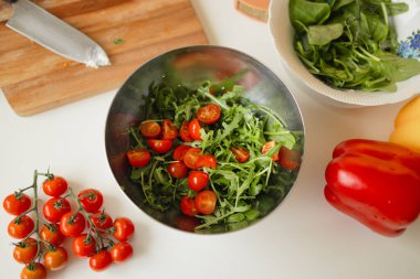 Taze domatesli sağlıklı sebze salatası, salatalık, soğan, ıspanak ve marul tabakta. Diyet menüsü. Üst Manzara. Yüksek kalite fotoğraf