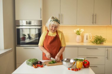 Kadın elleri mutfakta sebze kesiyor. Kırpılmış bir kadının mutfak tahtalarını keserken, evde yemek hazırlarken görüntüsünü kapat. Vejetaryen sağlıklı yiyecekler