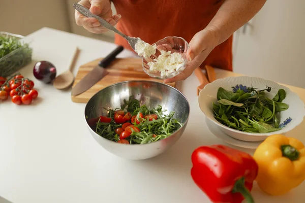 Bayan taze sebze salatası pişiriyor, sprey peyniri ekliyor ve bowling 'e baharat katıyor, evde sağlıklı vejetaryen yemekleri yiyor, yakından çekiyor. Yüksek kaliteli FullHD görüntüler