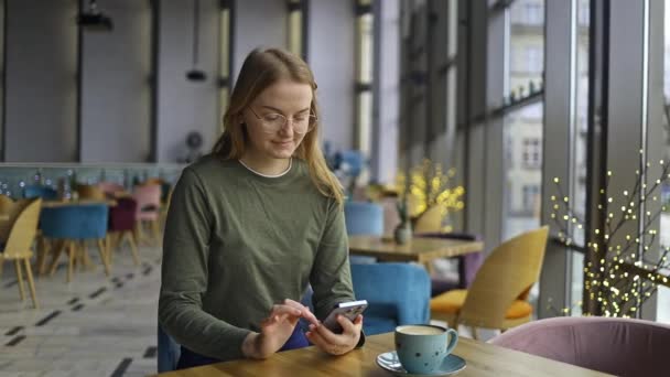 Счастливая Красивая Девушка Пользующаяся Мобильным Телефоном Пока Пьет Кофе Кафе — стоковое видео