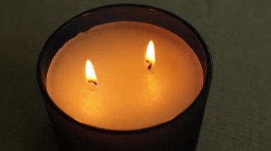 Masaya soya mumu üflüyorum. Kavanozda bir mum. Aromaterapi. Kokulu mum. Sade, gri bir kazak. Söndürmekten ve mumları söndürmekten çıkan duman. Yüksek kaliteli FullHD görüntüler