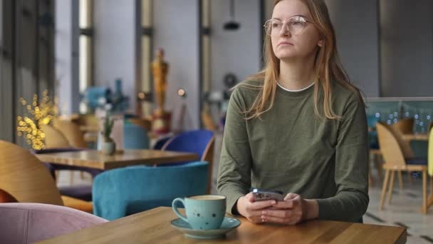 Szczęśliwa Piękna Dziewczyna Pomocą Telefonu Komórkowego Podczas Picia Kawy Kawiarni — Wideo stockowe