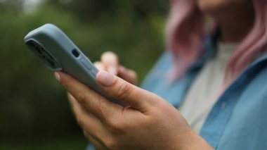 Arka bahçede akıllı telefon kullanan kadın eller, arama ya da sosyal ağ konsepti, hipster kadın arkadaşlarına SMS mesajı yazıyor.