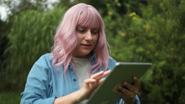 아름답고 행복한 코카서스 여성은 그녀의 디지털 태블릿을 야외에서 사용했습니다 — 비디오