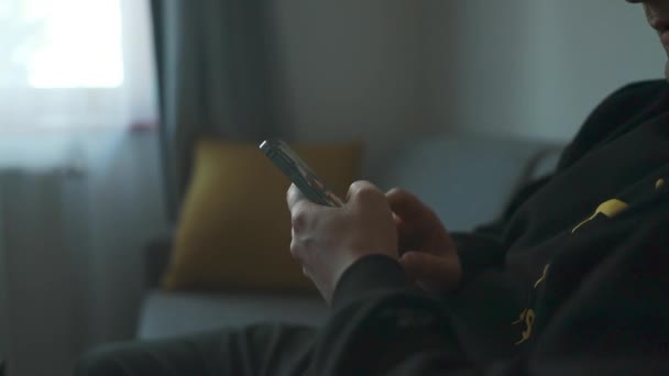 Mann Bedient Smartphone Wohnbereich Während Auf Dem Sofa Modern Gestalteten — Stockvideo