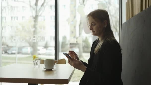 Junge Fröhliche Geschäftsfrau Die Anzug Hält Handy Chat Mit Tasse — Stockvideo