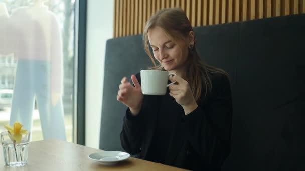 Biała Bizneswoman Siedzi Przy Oknie Pije Kawę Latte Relaksując Się — Wideo stockowe