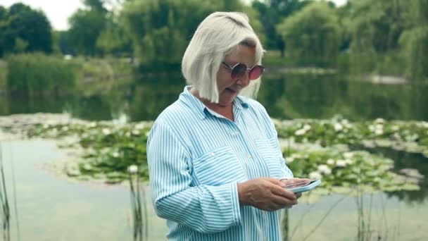 Glad Äldre Aktiv Kvinna Offentlig Park Tittar Smartphone Teknik Som — Stockvideo
