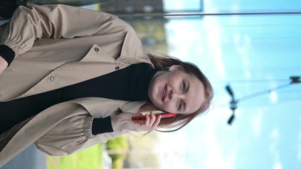 ビジネス30S オフィスの近くに電話が付いている白人成功したビジネスマン 屋外で立っている間スマートフォンで話すスタイルのファッションオフィスの服の美しい笑顔の女性の肖像 スマートフォン — ストック動画