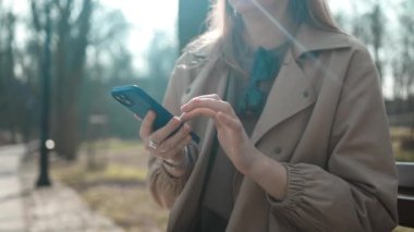 Çekici genç kız şehirde akıllı telefon kullanıyor. Gün batımında yürüyor. Etrafına bak.