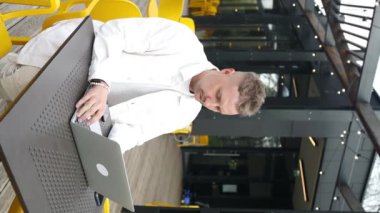 Yakışıklı beyaz üniversiteli çocuk dizüstü bilgisayar kullanarak uzaktan eğitim semineri, uzaktan üniversite webinarı ya da açık havada sanal sınıf toplantısı yapıyor.