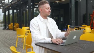 Yakışıklı beyaz üniversiteli çocuk dizüstü bilgisayar kullanarak uzaktan eğitim semineri, uzaktan üniversite webinarı ya da açık havada sanal sınıf toplantısı yapıyor.