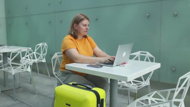 スタイリッシュなカジュアルな服の若い白人女性の乗客は 航空ラウンジ待機国際空港のラップトップコンピュータでオンライン会議をトレーニングしています 高品質のフルHd映像 — ストック動画