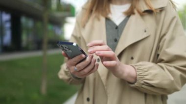 Kapatın genç işkadını öğrenci cep telefonunu elinde tutarak internet sohbetinde mesaj yolluyor şirket ağlarında haberleri okuyor. Milenyum kadınları açık havada akıllı telefon kullanarak çevrimiçi çalışır.