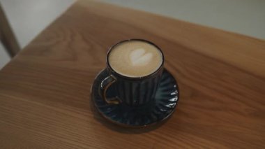Kapuçino ya da köpüklü latte, kahve dükkanındaki beyaz kahve fincanı. Kafe ve bar, barista sanat konsepti. Yüksek kaliteli FullHD görüntüler