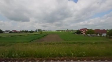 Tepeler, tarlalar, ormanlar, tren raylarının kesiştiği yer. Güneşli bir günde yolculuk manzarası. Yüksek kalite 4k görüntü