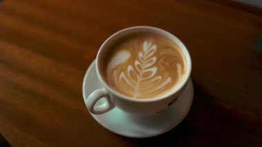 Kafede, beyaz bardakta, ahşap masada, ışıklandırma arka planında kahve. Yüksek kalite 4k görüntü