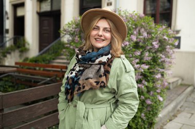 Güzel, genç ve rahat bir kadın sonbaharda şehir caddesinde temiz havanın tadını çıkarıyor. Yüksek kalite fotoğraf