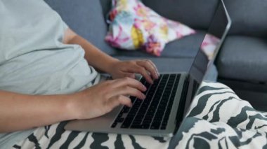 Sabahın erken saatlerinde arka bahçede otururken klavyede yazan beyaz bir kadın. Kadın yazar işini gündoğumunda bitirdi. Yüksek kaliteli FullHD görüntüler