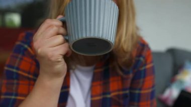 Arka bahçede kanepede oturup kahve ya da çay içen hayalperest genç bayanı yakından çek. Rahat sahne Yüksek kalite FullHD görüntüler